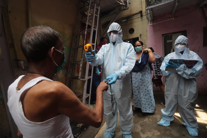 A doctor checks the temperature of a man in Mumbai, India, on June 20, 2020. 