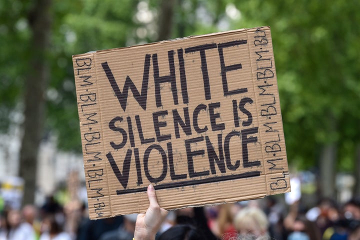 LONDON, UNITED KINGDOM - 2020/06/21: A Black Lives Matter protester holds a placard saying White Silence is Violence during the demonstration.Black Lives Matter protests continue in the United Kingdom after the death of George Floyd killed by a police officer in Minneapolis. (Photo by Dave Rushen/SOPA Images/LightRocket via Getty Images)