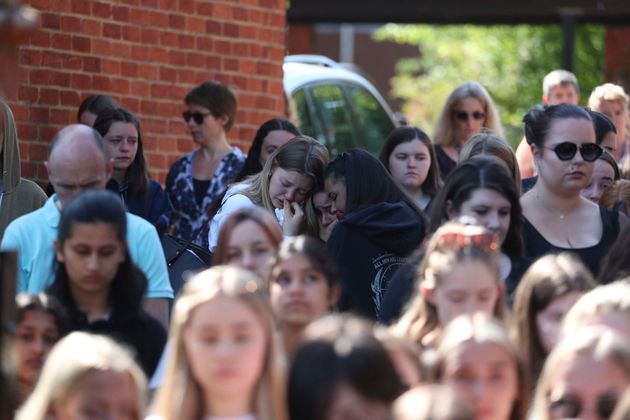 Colleagues and pupils of teacher James Furlong stand together to take part in a period of silence at the Holt School, in Wokingham.