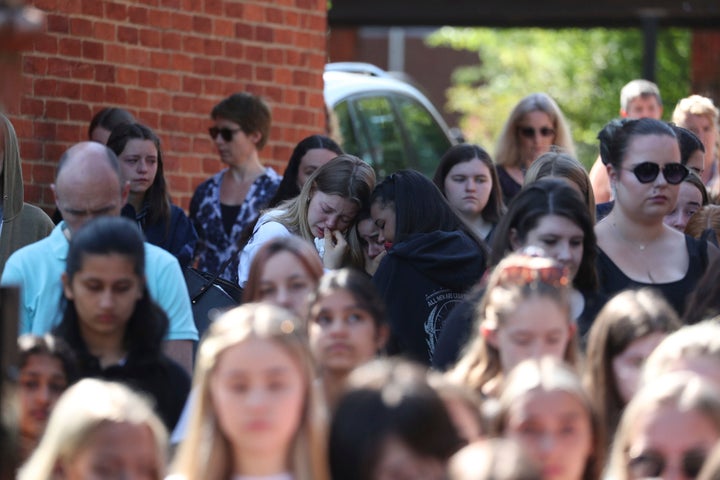 Colleagues and pupils of teacher James Furlong stand together to take part in a period of silence at the Holt School, in Wokingham.