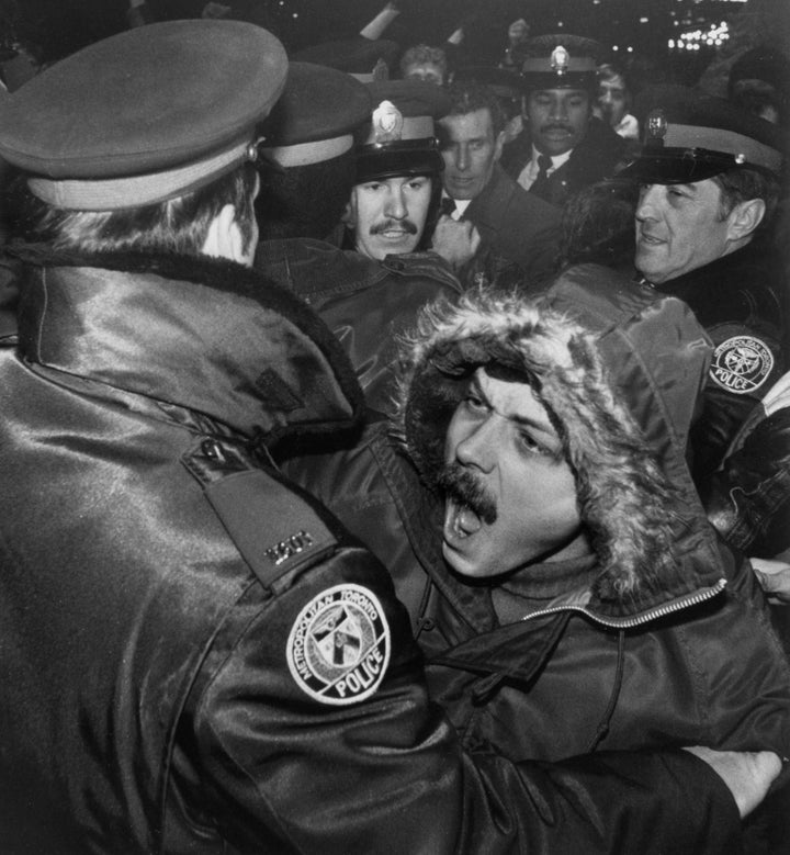 A man is restrained by Toronto police outside the Ontario Legislature after about 1,000 gay rights demonstrators marched through the downtown area protesting the February 5, 1981 arrest of nearly 300 men in four city steam baths.