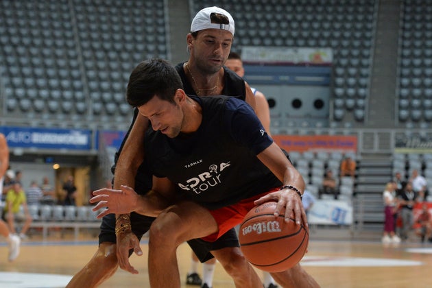 In this photo taken on Thursday June 18, 2020, Bulgarian tennis player Grigor Dimitrov, rear, plays basketball...