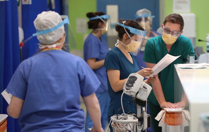 In this photo taken on May 4, 2020, medical staff in face masks and shields work in the respiratory emergency department at Craigavon Area Hospital in Co Armagh, Northern Ireland