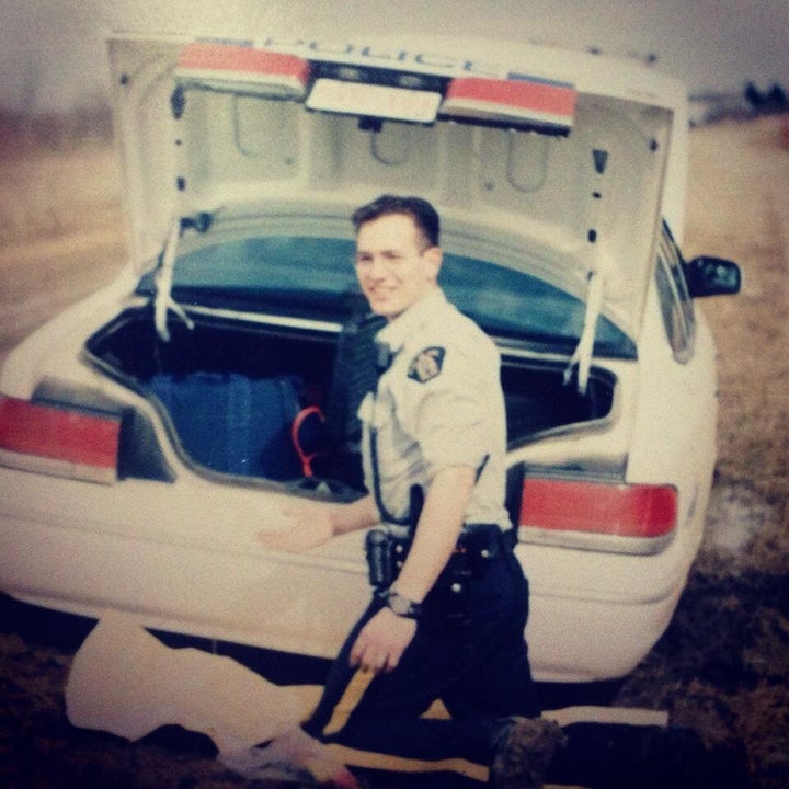 The writer smiles behind a stuck police car.