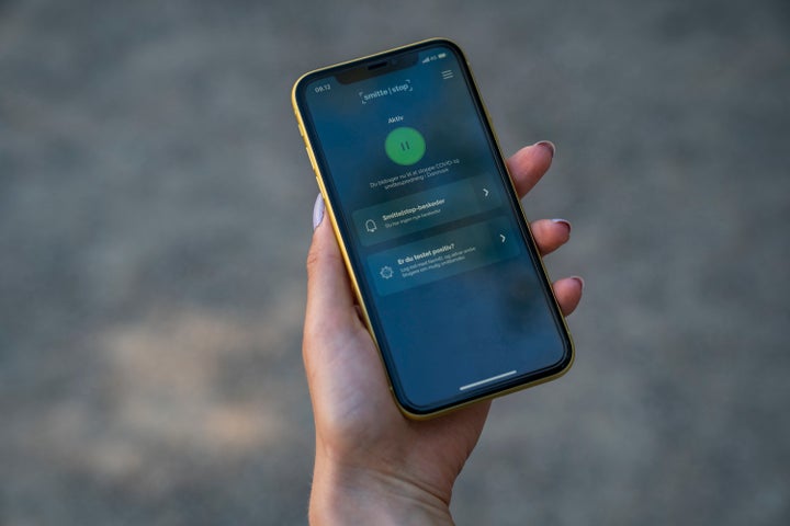 File photo of a woman holding a smart phone showing a COVID-19 infection tracing app in Copenhagen on June 18, 2020.