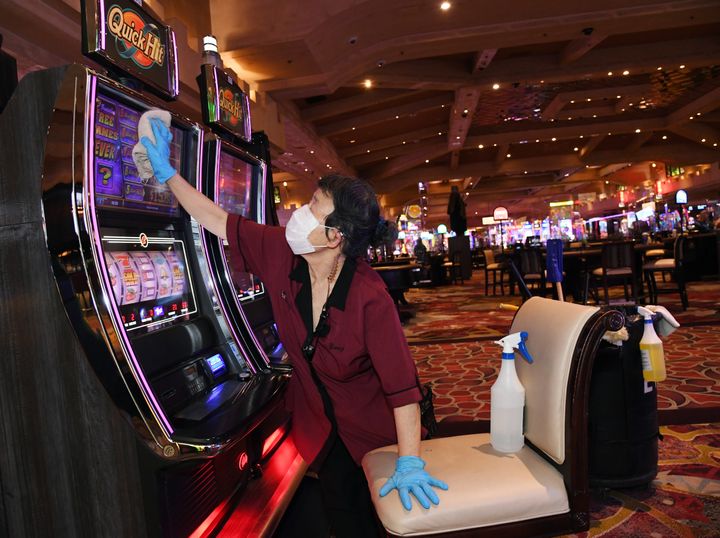 An employee sanitizes slot machines at Excalibur Hotel & Casino after the property opened for the first time since mid-March.