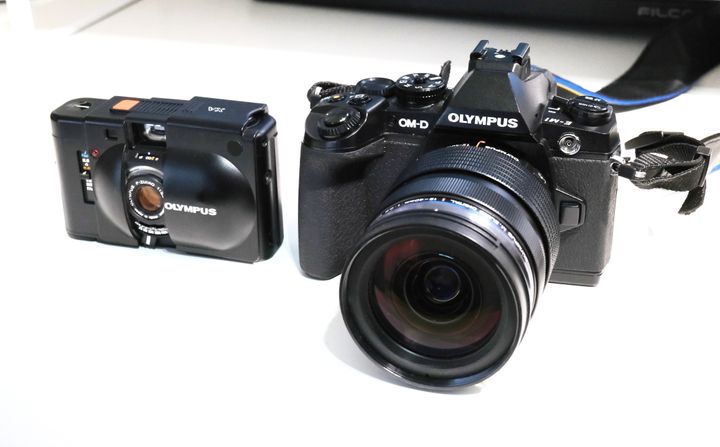 筆者が所有するオリンパスのカメラ。左がフィルムカメラのOLYMPUS XA（1979年発売）。右がデジタルミラーレスカメラのOLYMPUS OM-D E-M1（2013年発売）
