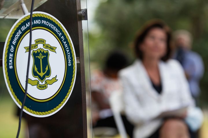 The seal of the State of Rhode Island decorates a podium as Gov. Gina Raimondo announces that she has signed an executive order that will remove the phrase "Providence Plantations" from the state's formal name when it appears on some official documents and executive agency websites.