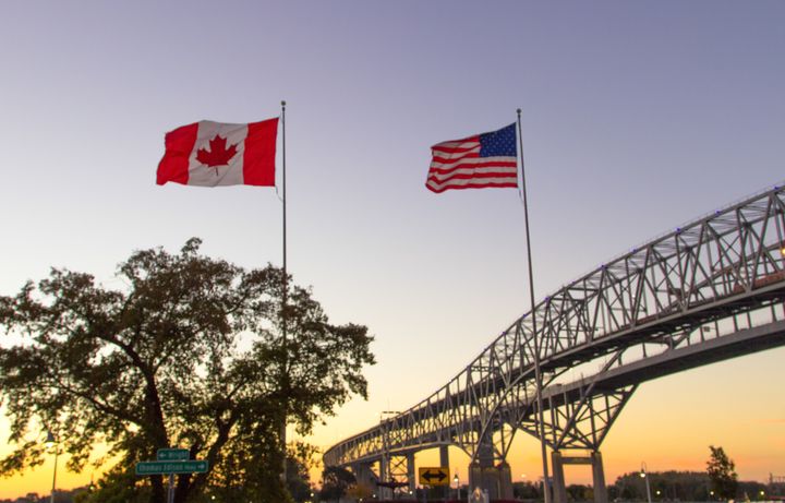 The Canadian and U.S. flags fly over the twin spans of the Blue Water Bridge between Sarnia, Ont., and Port Huron, Mich., in this undated photo. Canada has beaten the U.S. for the first time on a ranking of most competitive economies.