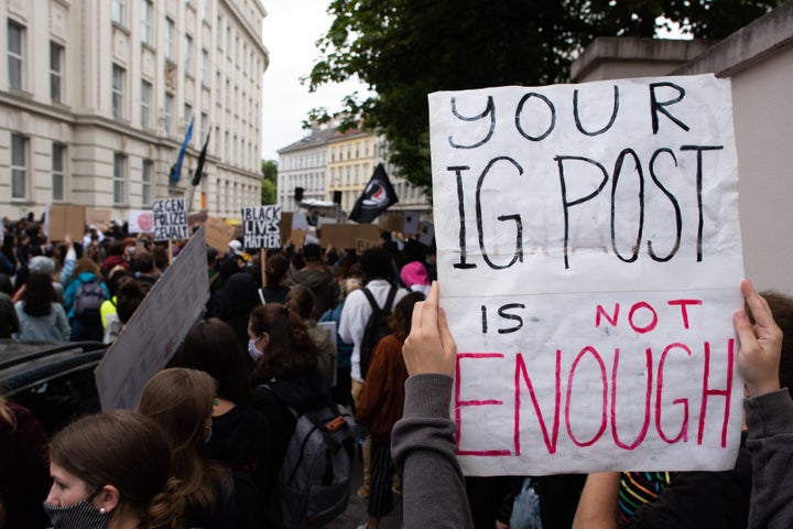 A protester holds up a sign reading 'Your IG post is not enough' during a Black Lives Matter protest in front of the U.S Embassy on June 5, 2020 in Vienna, Austria.