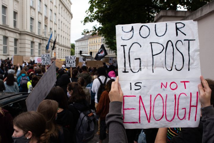 A protester holds up a sign reading 'Your IG post is not enough' during a Black Lives Matter protest in front of the U.S Embassy on June 5, 2020 in Vienna, Austria. 