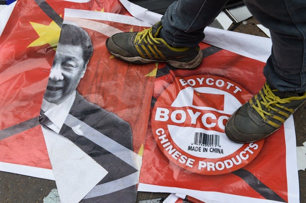 An activist of Gujarat's Karni Sena organisation stands on a poster with the image of Chinese President...