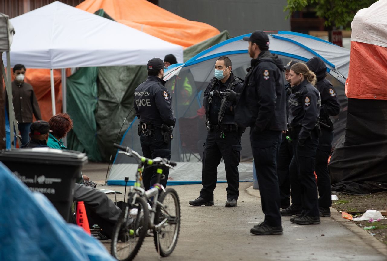Police officers are seen at a homeless camp at Oppenheimer Park in the Downtown Eastside in Vancouver, on April 26, 2020. 
