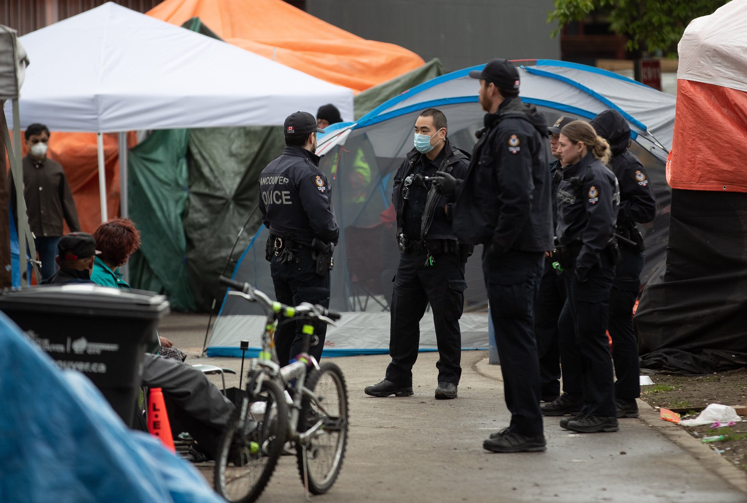 Police officers are seen at a homeless camp at Oppenheimer Park in the Downtown Eastside in Vancouver, on  April 26, 2020. 