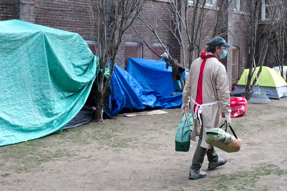 Doug Johnson Hatlem, a worker at The Sanctuary, a respite centre in Toronto, carries tents to be distributed...