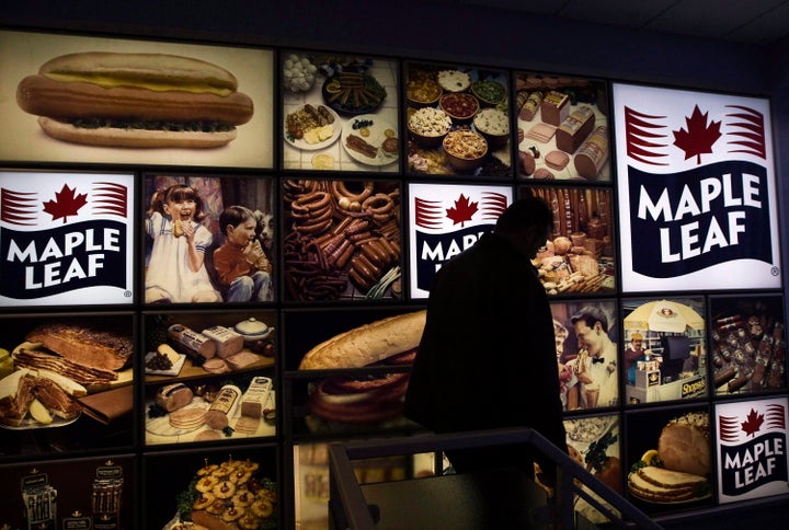 A Maple Leaf Foods employee walks past a Maple Leaf sign at the company's meat facility in Toronto on Dec. 15, 2008.