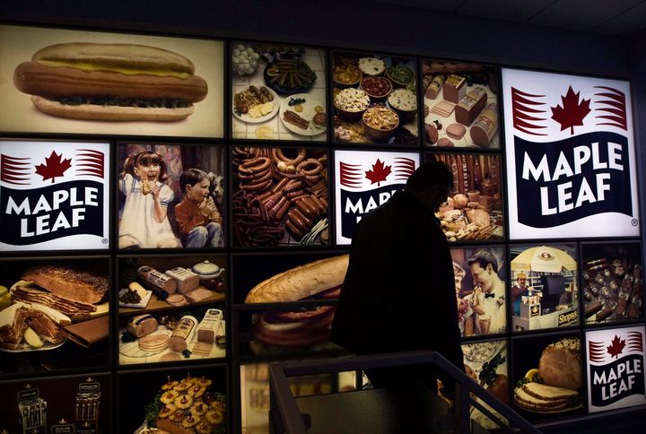 A Maple Leaf Foods employee walks past a Maple Leaf sign at the company's meat facility in Toronto on Dec. 15, 2008.