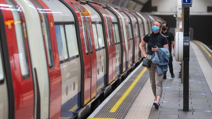A commuter wearing a protective face mask walks along the platform at Clapham Common underground station, London, as train services increase this week as part of the easing of coronavirus lockdown restrictions, Thursday May 21, 2020. (Dominic Lipinski/PA via AP)