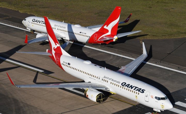 Qantas 737-800 aircraft parked on the east-west runway at Sydney Airport. 