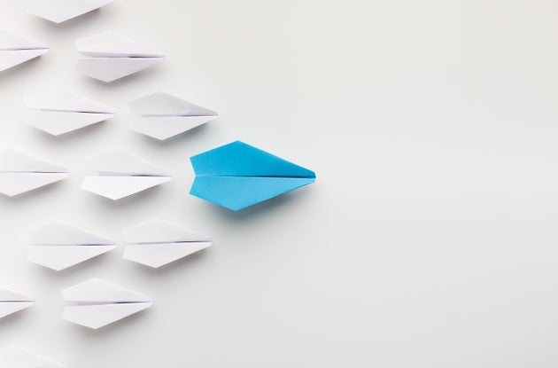 Religious leader. One blue paper plane leading group of white ones, top view, copy space