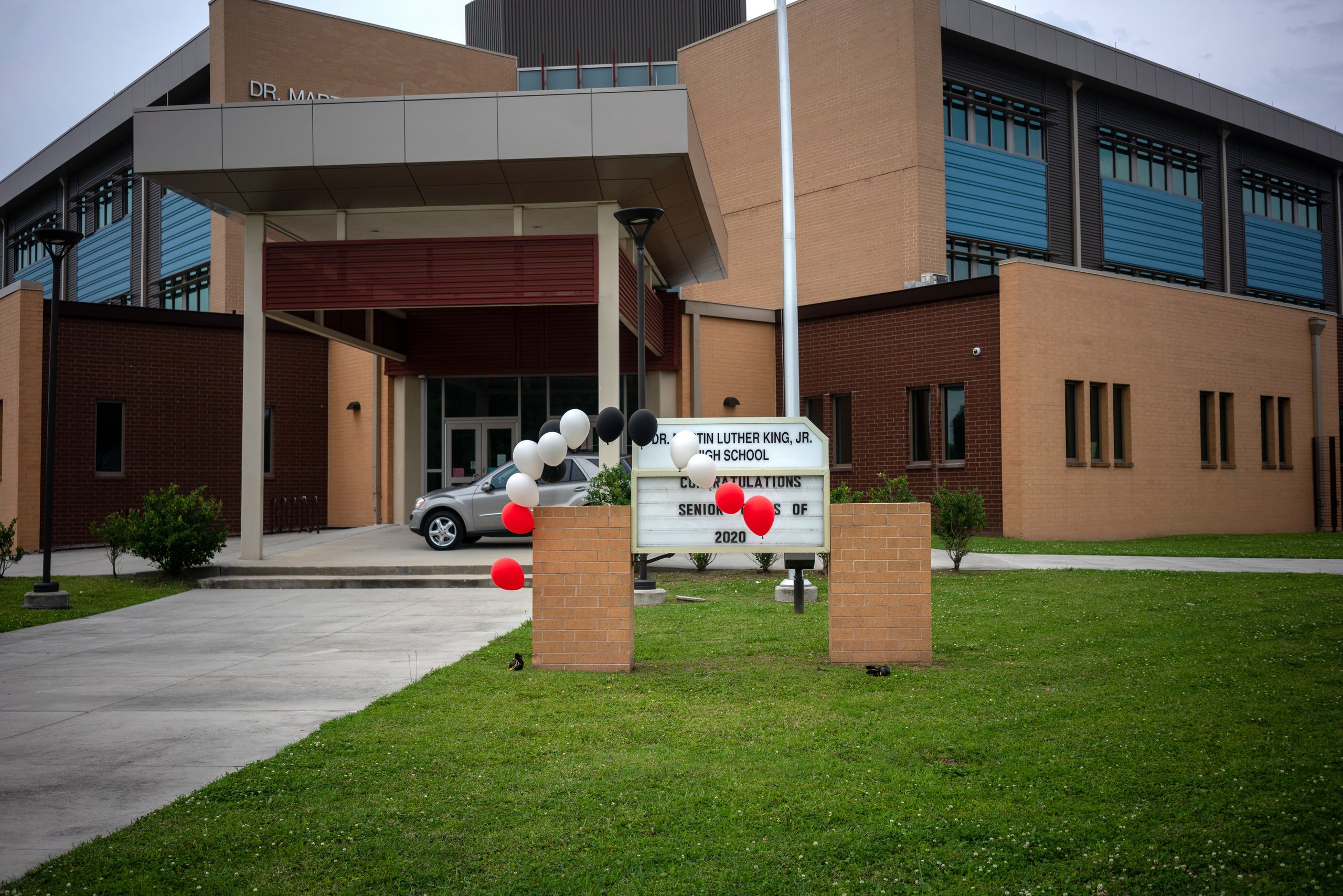 Balloons hang on a sign outside Dr. Martin Luther King Jr. High School in New Orleans on graduation day in late May.