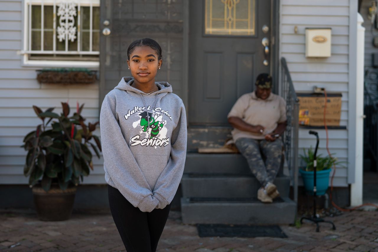 Satoriya Lambert stands in front of her home where she lives with her grandmother, Ether Bullock, 70, a retired teacher, who sits on the stairs. The house flooded up to the ceiling in 2005.