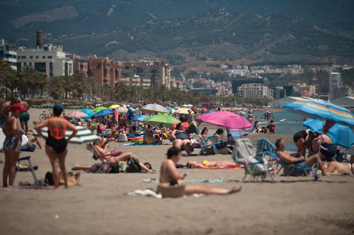 People sunbathing at Misericordia beach in Malaga, Spain - a popular destination for Brits