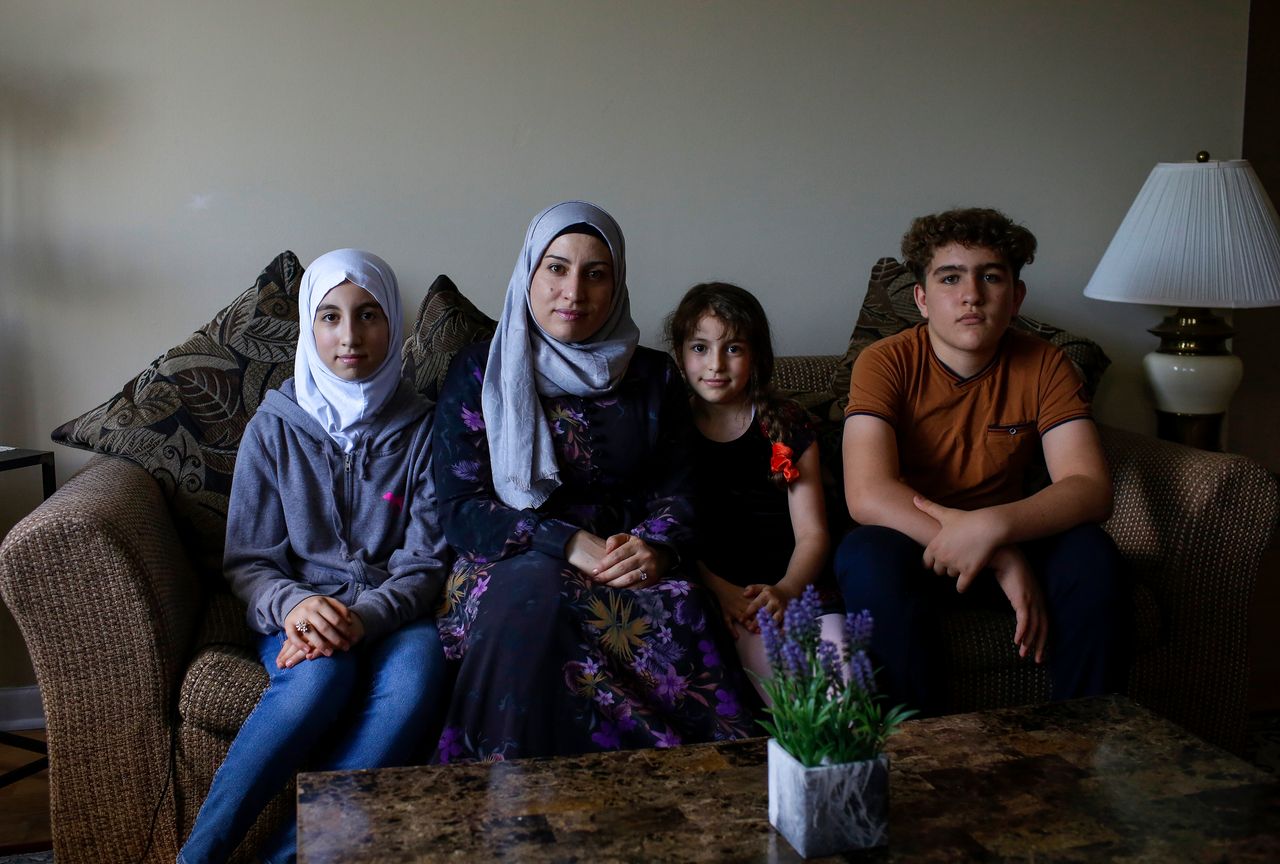 Mohamed Almadani (far right) is a faster reader in English, and often reads aloud for his mother, Nawar Almadani (second from left). He struggles to pay attention in his online classes as students talk over one another. "It's horrible," he said.