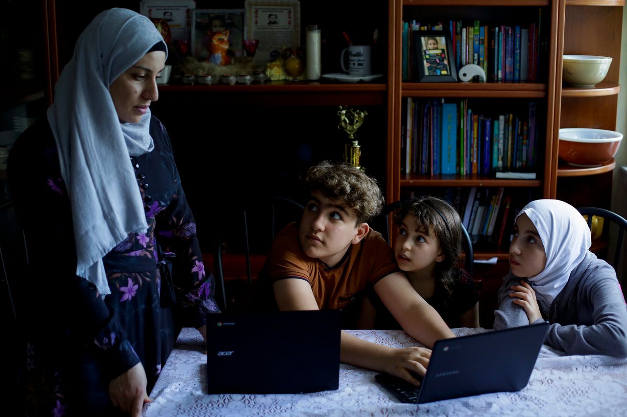Nawar Almadani, left, watches as her kids Mohamed, Esraa and Baian work on their computers at their apartment during the coronavirus outbreak on Wednesday, June 24, in Chicago. 