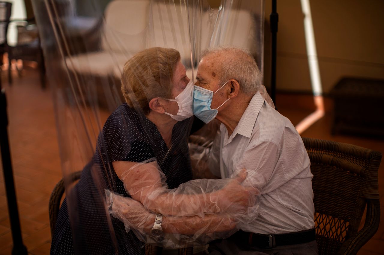 Σε γηροκομείο της Βαρκελώνης, η Αγκουστίνα Κανιαμέρο 81 ετών και ο Πασκουάλ Πέρεθ 84 ετών, αγκαλιάζονται και φιλιούνται ενώ τους χωρίζει μία πλαστική κουρτίνα, εφαρμόζοντας έτσι τους κανόνες υγιεινής για την προστασία από την εξάπλωση του COVID-19. Δευτέρα, 22 Ιουνίου.