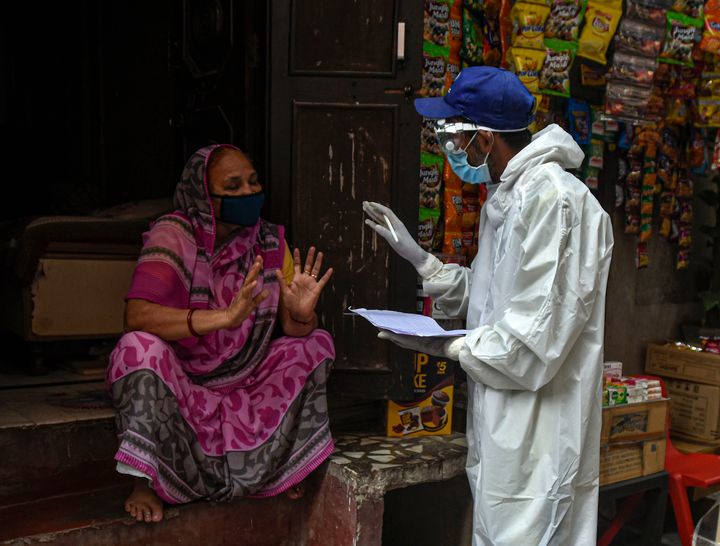 A health worker in PPE conducts a door to door screening survey for coronavirus in Karol Bagh's Ragarpura area, on June 26, 2020 in New Delhi, India. 