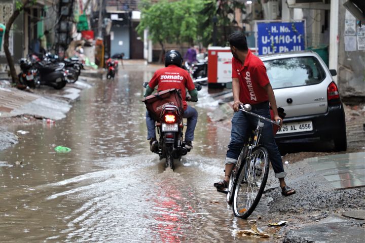 Zomato delivery boys move through water logged streets in Gurugram on the outskirts of New Delhi, India on 31 May 2020 (Photo by Nasir Kachroo/NurPhoto via Getty Images)