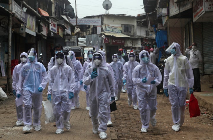 Health workers arrive to administer a medical camp in Mumbai, India.