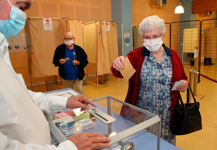 A woman casts a vote at a voting center during the second round of the municipal elections, in Saint Pee sur Nivelle, southwestern France, Sunday, 28, June, 2020. France is holding the second round of municipal elections in 5,000 towns and cities Sunday that were postponed due to the country's coronavirus outbreak. (AP Photo/Bob Edme)