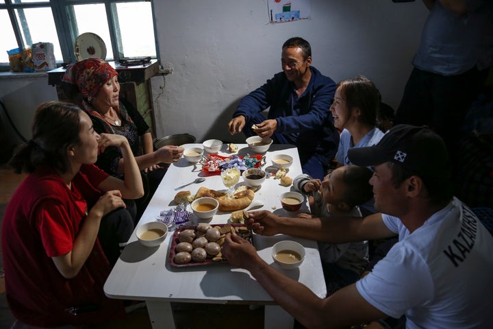 Gulnar Omirzakh, second right, and her husband, Baqytali Nur, third right, eat lunch with friends and family at their home in Shonzhy, Kazakhstan on June 13, 2020. 