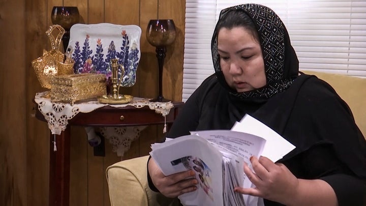 In this image from video, Zumret Dawut, a Uighur from China's far western Xinjiang region, holds documents she brought with her, at her new home in Woodbridge, Va., on Monday, June 15, 2020. Dawut says in China, she was forcibly sterilized for having a third child after being released from a Xinjiang detention camp.