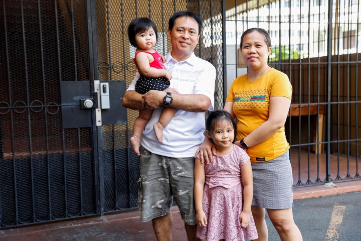 Judith and Jose Ramirez, a housekeeper and an electrician who were both temporarily laid off from their jobs at the Sheraton Waikiki Hotel due to the business downturn caused by the coronavirus outbreak, pose with their daughters Mary Amber, 1, and Mary Ashley, 5, outside their home in Honolulu, Hawaii, U.S. April 29, 2020. 