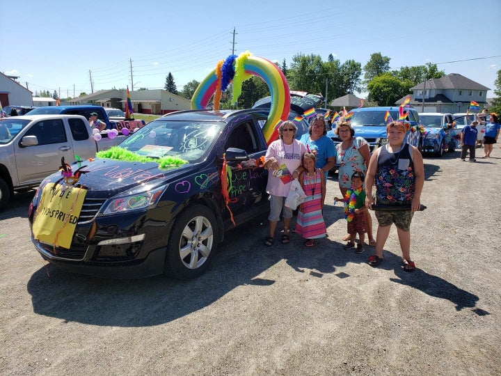 Participants in the Pride parade on June 27, 2020 pose with their bedazzled vehicle in Emo, Ont.