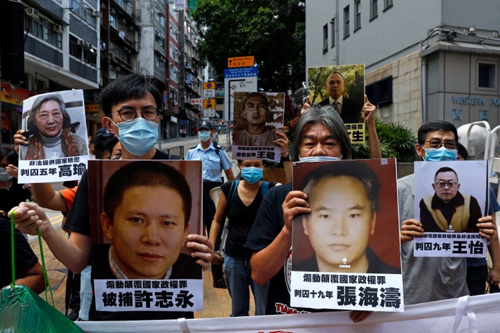 Pro-democracy demonstrators hold up portraits of jailed Chinese civil rights activists, lawyers and legal activists as they m