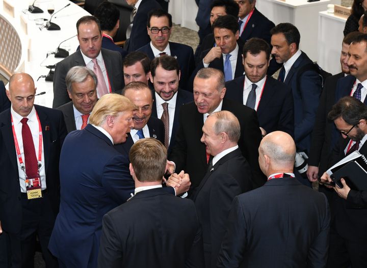 Donald Trump shakes hands with Russian President Vladimir Putin as Turkey's President Recep Tayyip Erdogan (second from right) and United Nations Secretary-General Antonio Guterres (left) join them on the sidelines of the G-20 summit in Osaka, Japan, on June 29, 2019. 