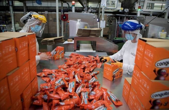 Dos trabajadoras empaquetan Conguitos.