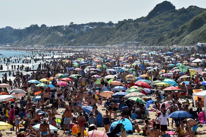 Beachgoers enjoy the sunshine as they sunbathe and swim on Bournemouth Beach in southern England on June 25.