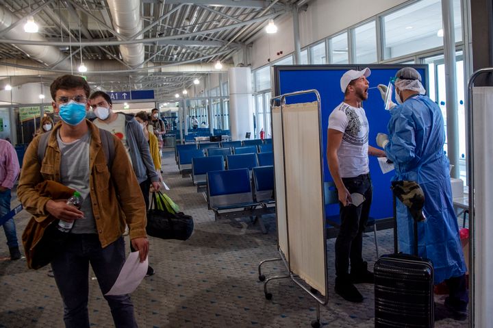 Αθήνα 15 Ιουνίου 2020: Ιατρικό προσωπικό διενεργεί τεστ για κορονοϊό σε ταξιδιώτες που μόλις έχουν φτάσει από την Ιταλία στο αεροδρόμιο Ελ.Βενιζέλος. Η Ελλάδα έχει άρει τις απαγορεύσεις για όσους ταξιδεύουν από χώρες της ΕΕ, ενόψει και της τουριστικής σεζόν. Ταξιδιώτες από χώρες «υψηλού κινδύνου» όπως η Βρετανία, θα υποβάλονται πάντως υποχρεωτικά σε τεστ και θα ισχύει περίοδος καραντίνας. Μία εβδομάδα εάν το τεστ βγει αρνητικό, δύο εβδομάδες εάν βγει θετικό. (Photo by Milos Bicanski/Getty Images)