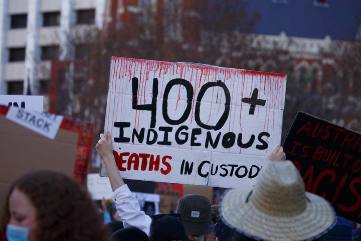 A protester holds up a sign during the Black Lives Matter protest and march outside Brisbane Town Hall. 