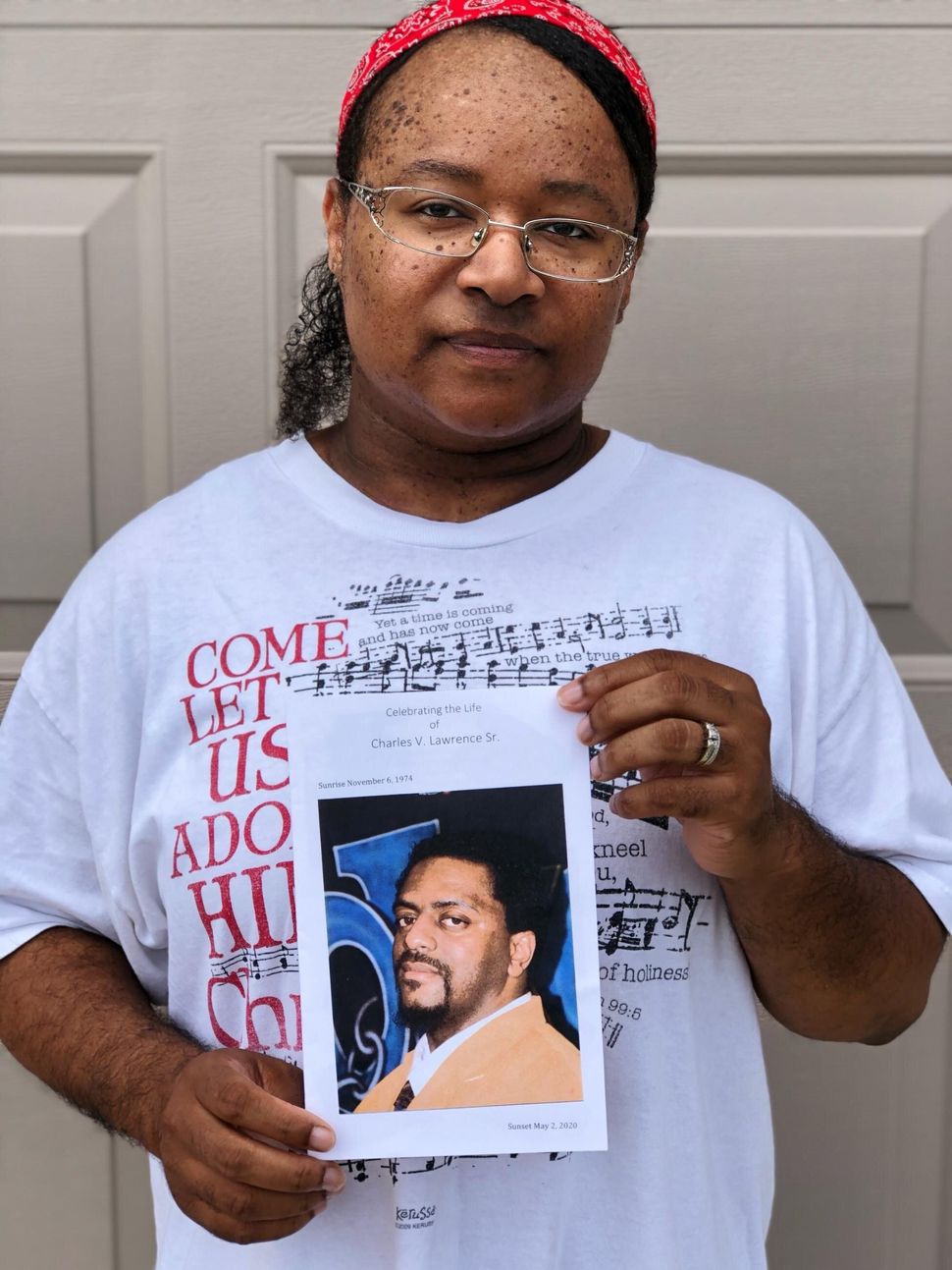 Sanya Lawrence holds a photo of her husband, Charles Lawrence, who died from the coronavirus in May 2020.