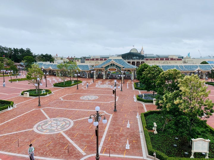 東京ディズニーランドのエントランスの写真。地面には、感染予防策としてソーシャルディスタンスを保てるよう印が付いている