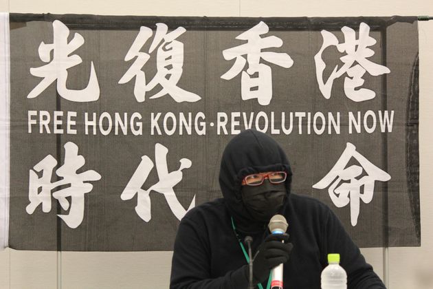 登壇した在日香港人。背後は「香港を取り戻せ、時代革命だ」
