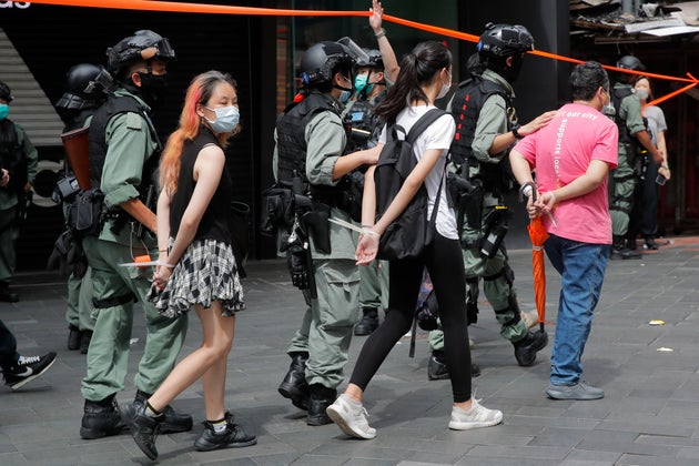 Police detain protesters after a protest in Causeway Bay before the annual handover march in Hong Kong,...