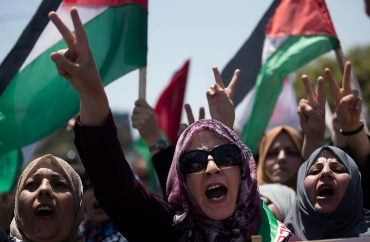 Palestinian women chant slogans and flash the victory sign as they demonstrate against Israeli plans for the annexation of parts of the West Bank