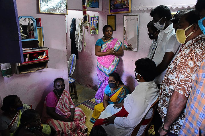 A church priest (C bottom) consoles family members of Jayaraj, 58, and son Bennix Immanuel, 31, allegedly tortured at the hands of police in Sathankulam, Thoothukudi district in Tamil Nadu on June 28, 2020.